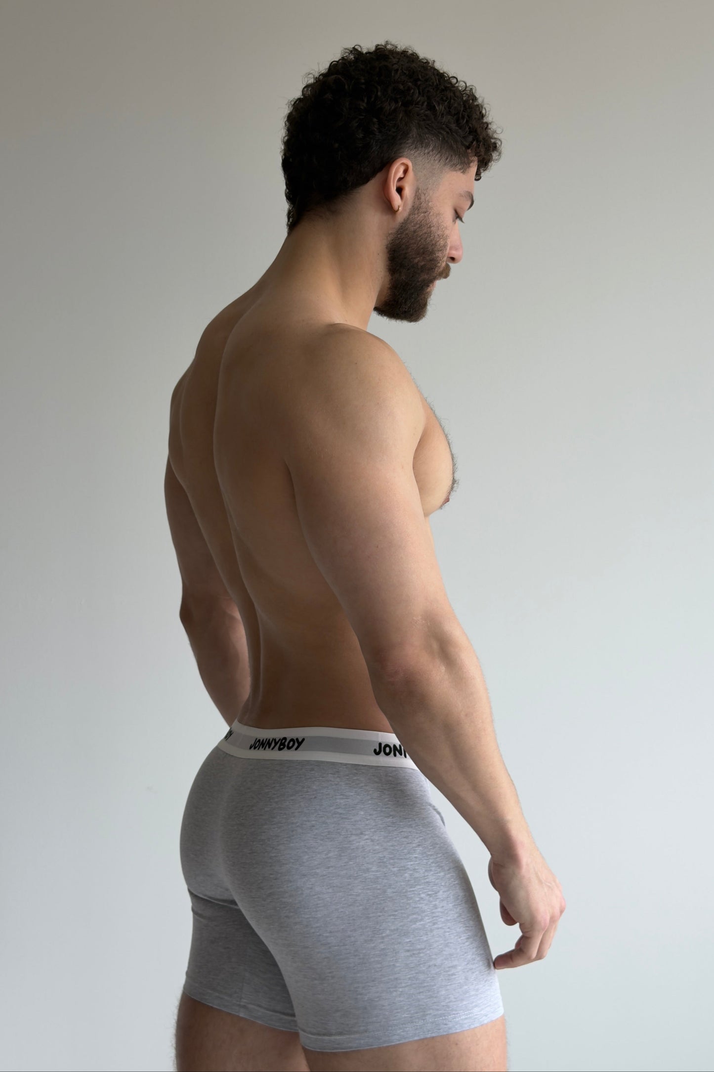 Man wearing white underwear against a plain background