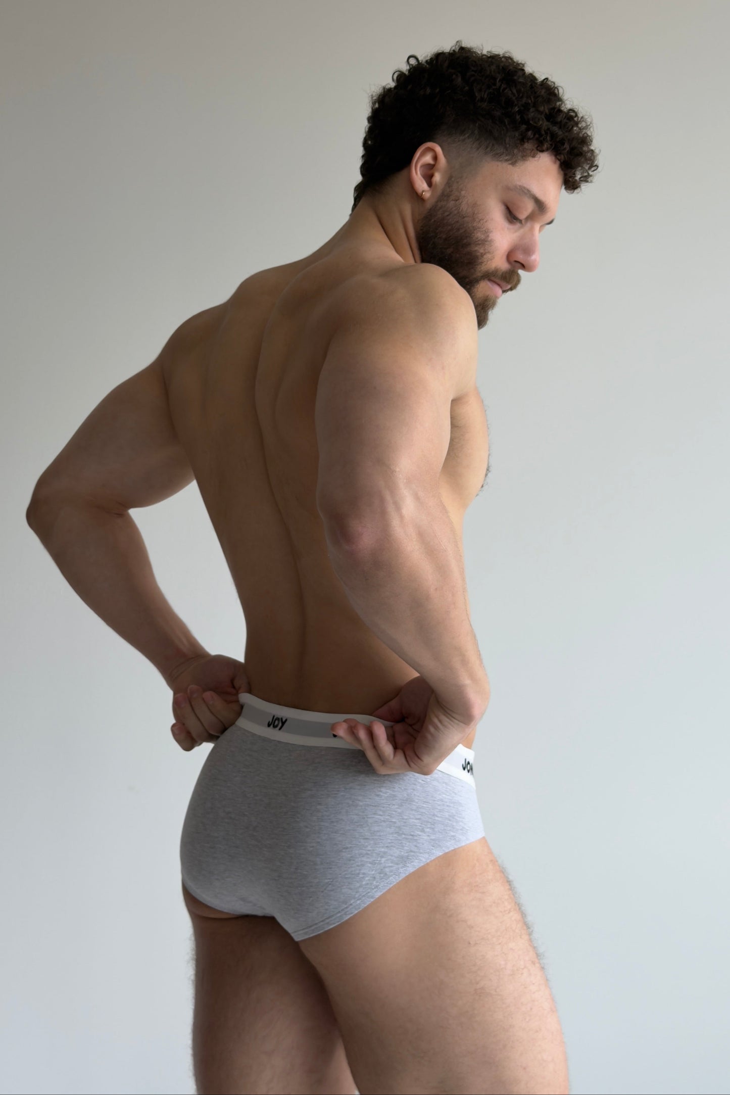 Man wearing white underwear against a plain background