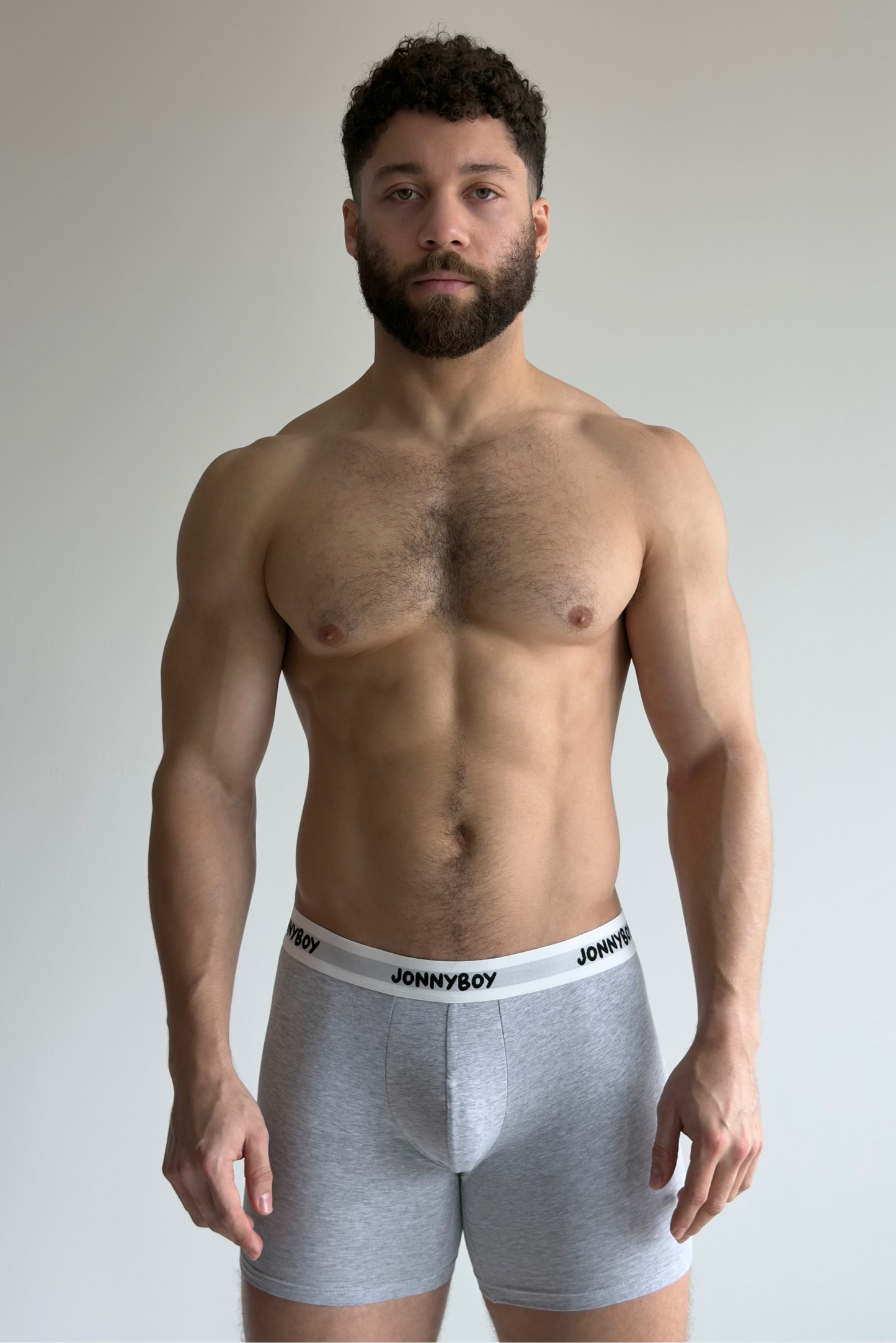 Man wearing gray underwear with 'JOHNNYBOY' brand label against a plain background