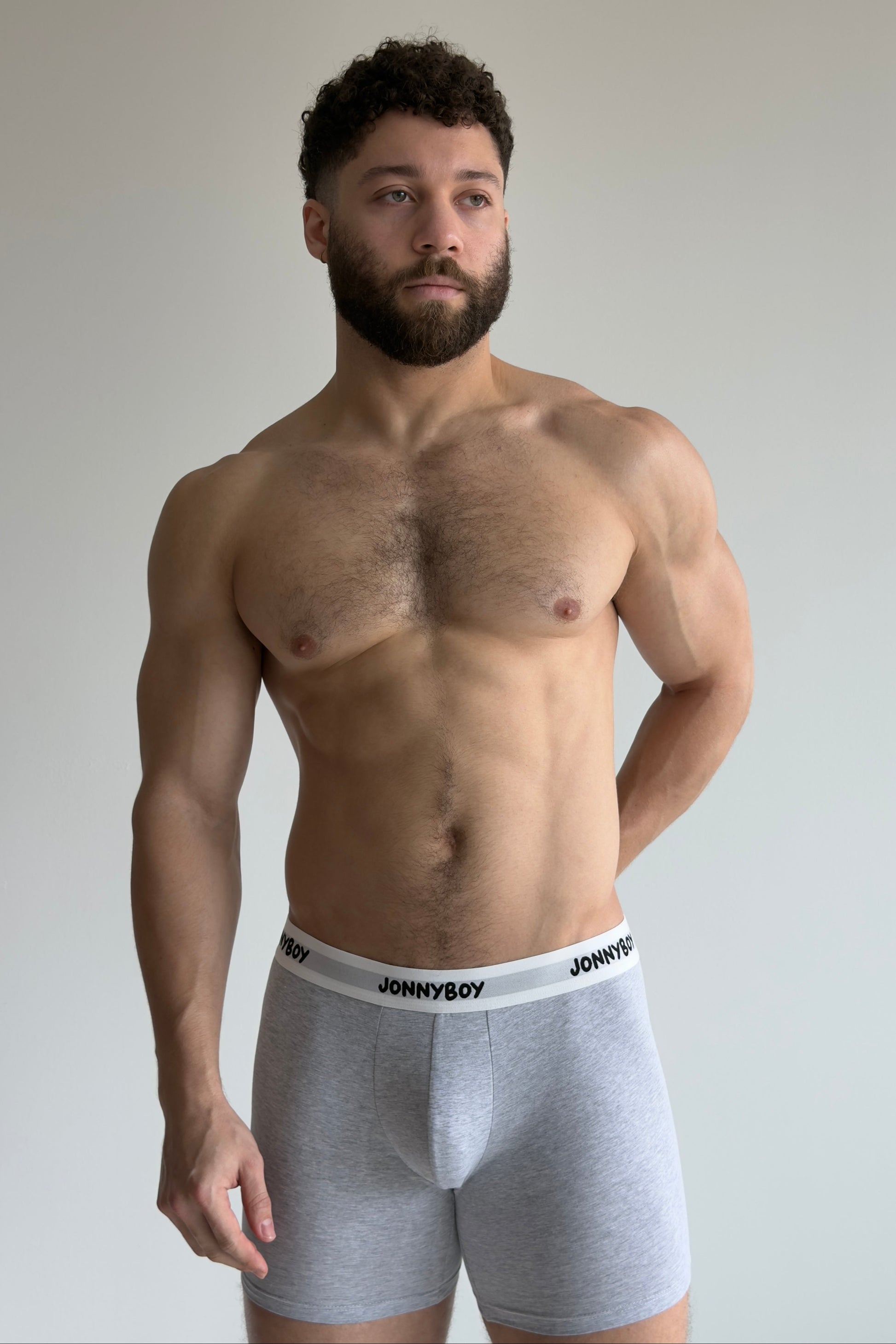 Man wearing gray underwear with 'JOHNNYBOY' brand label against a plain background
