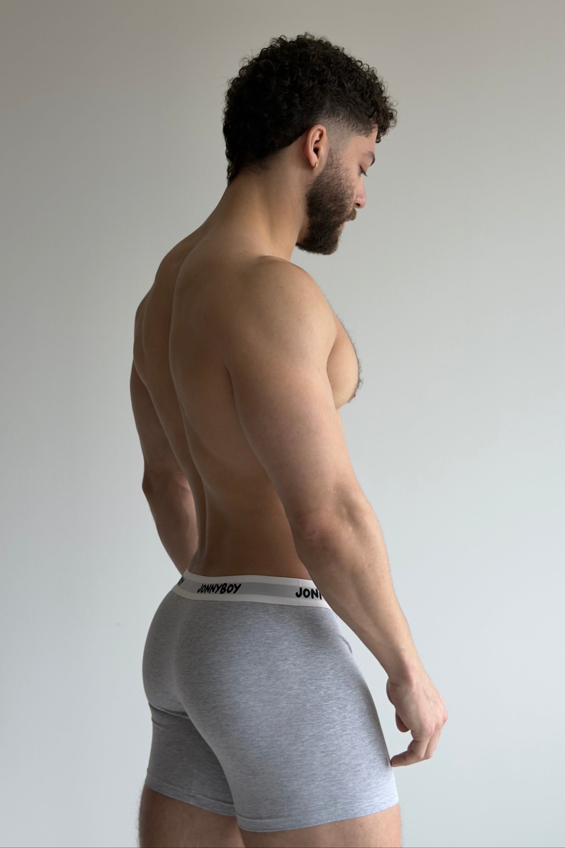Man wearing white underwear against a plain background