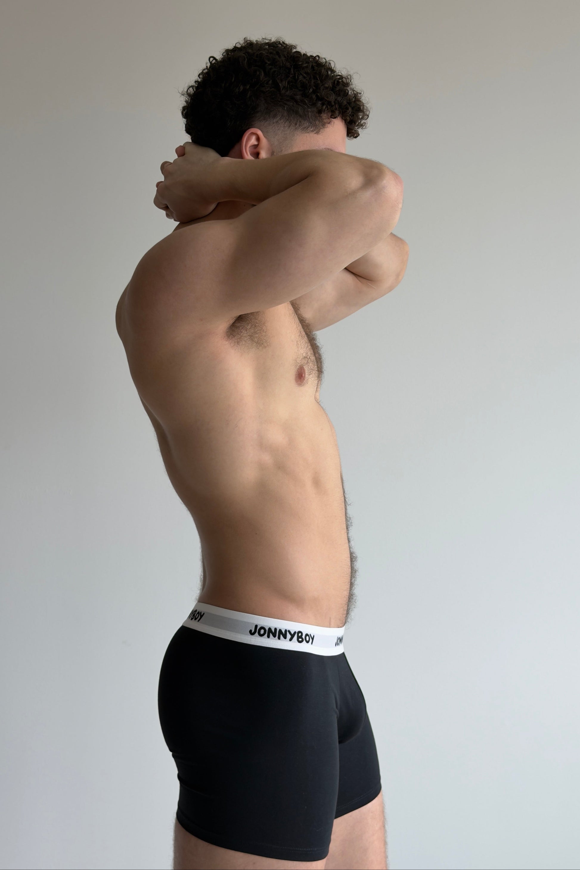 Person flexing arm muscles with a neutral background