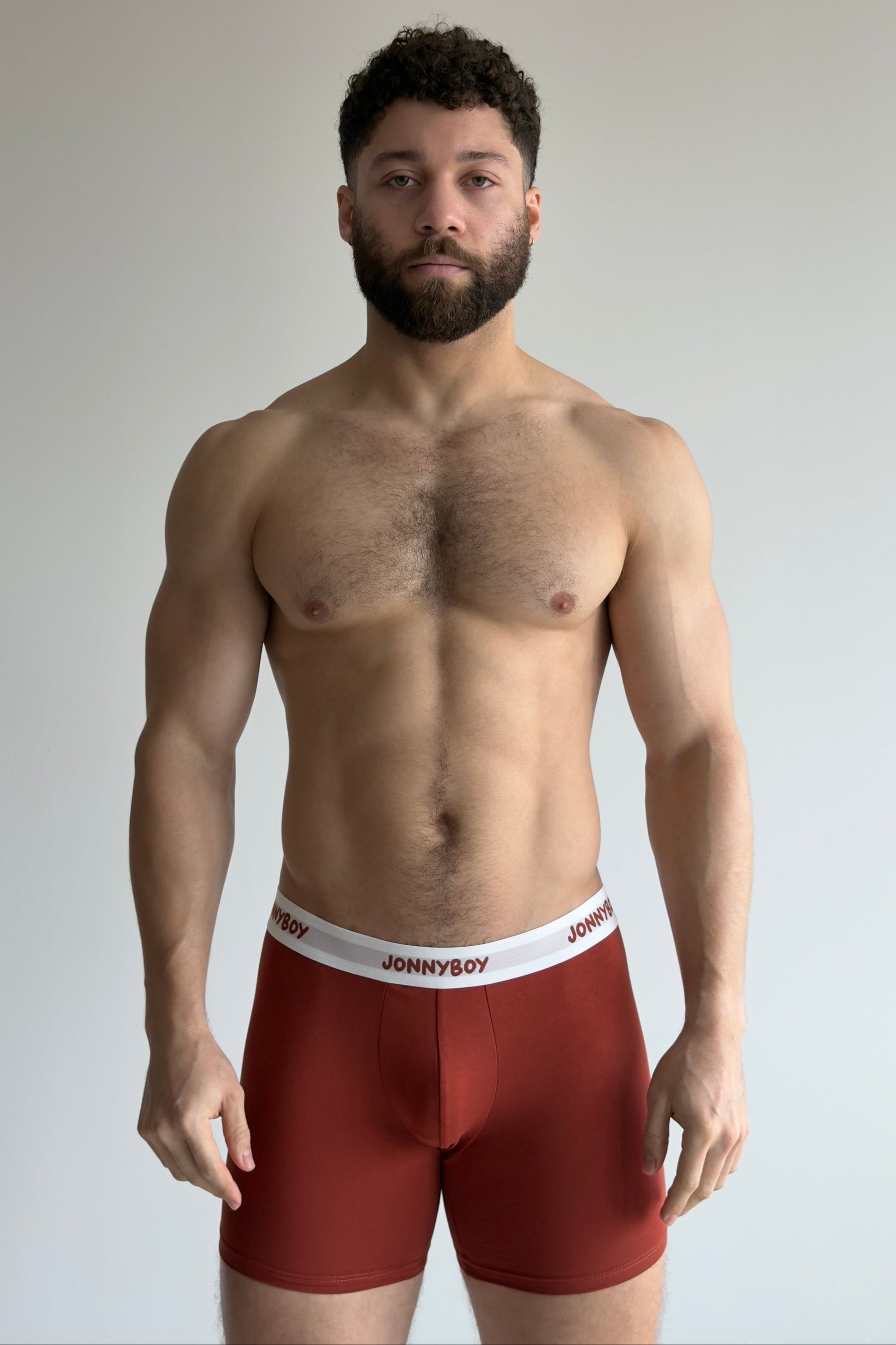 Man wearing red underwear with 'JOHNNYBOY' brand logo on a plain background